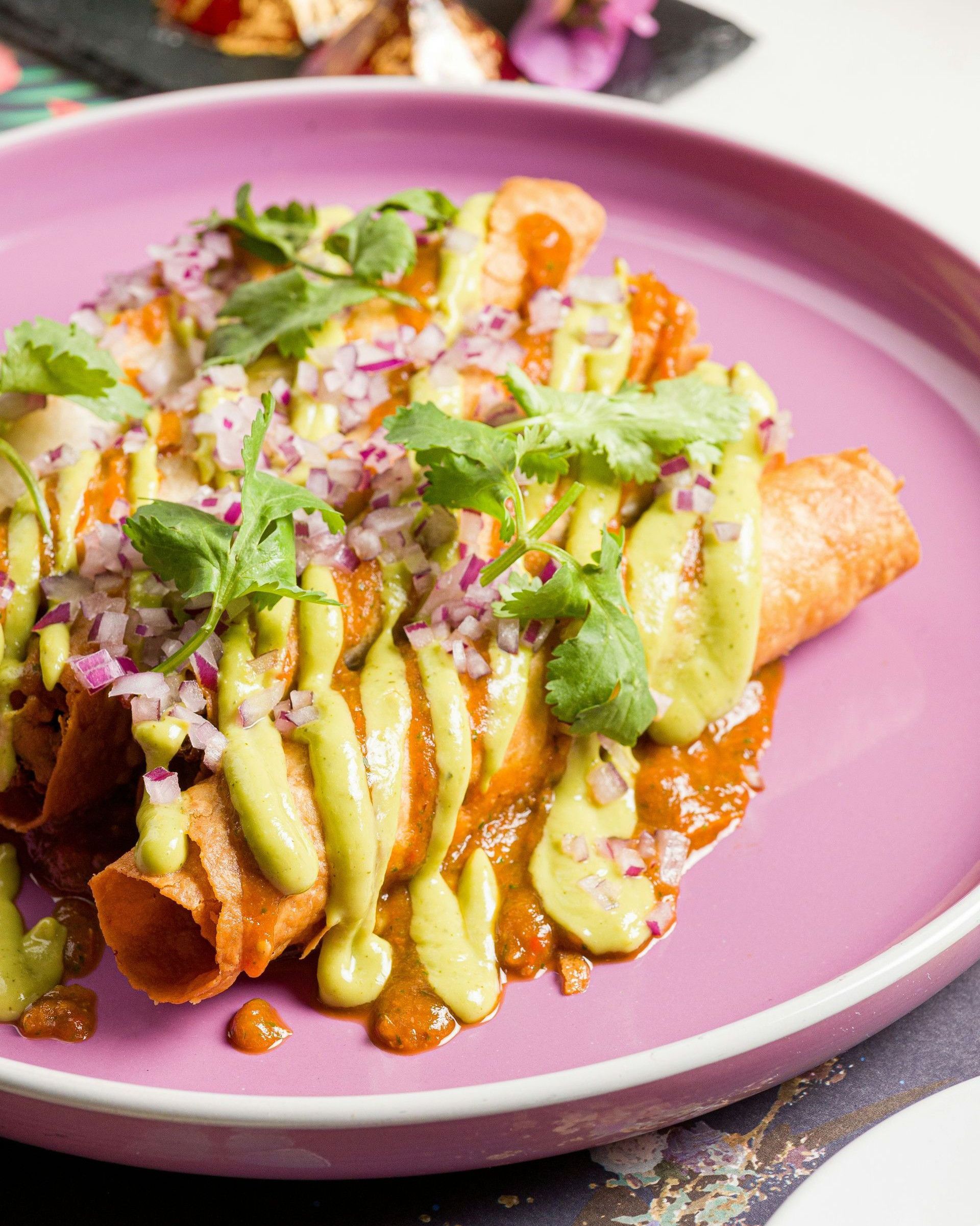 a pink plate topped with food on top of a table